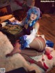 A woman with blue hair sitting on top of a white rug.