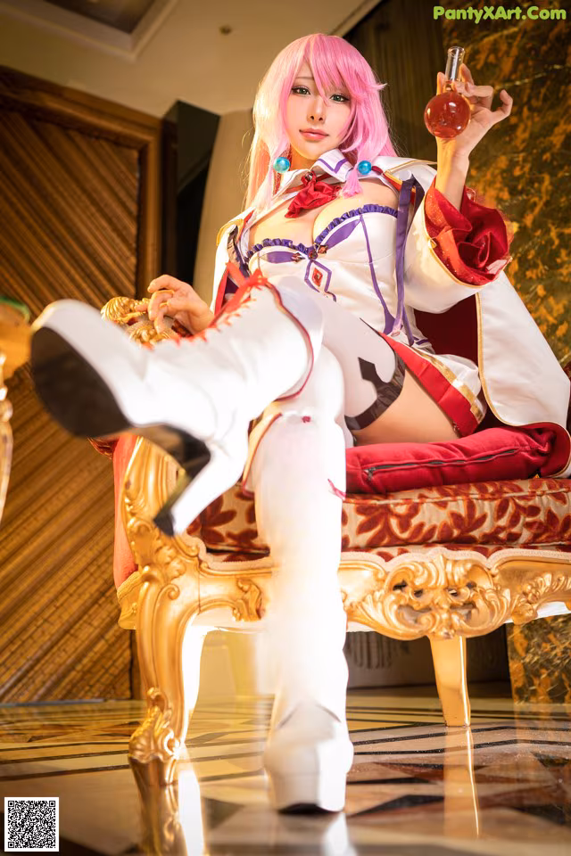 A woman sitting on a chair holding a bottle of perfume.