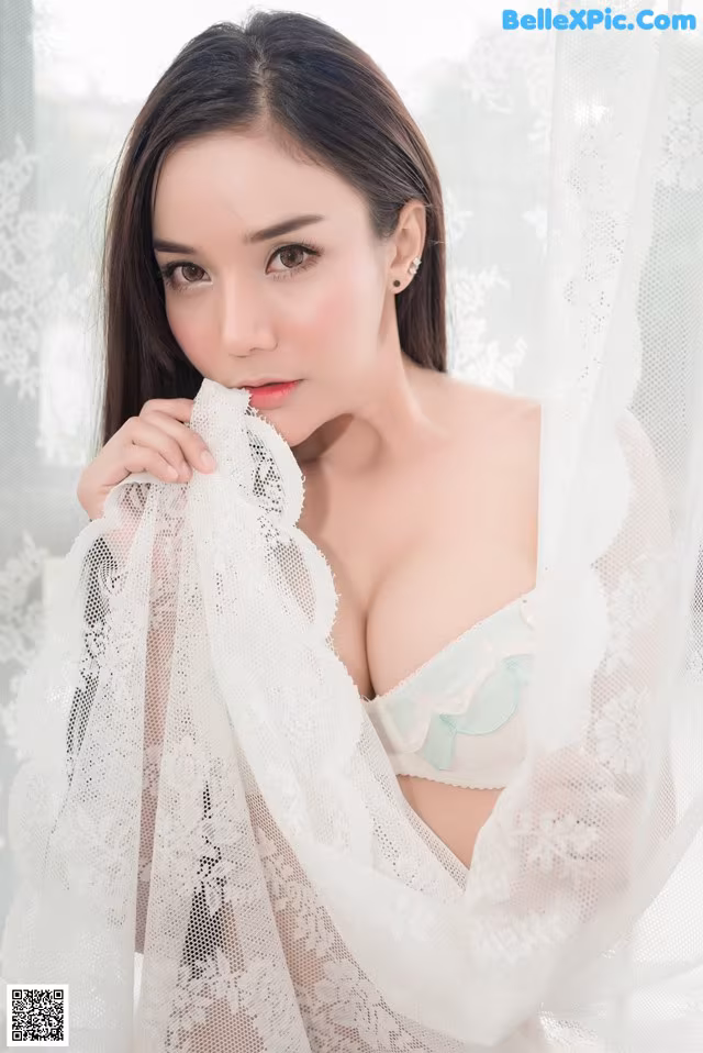 A woman in a white lingerie posing for a picture.