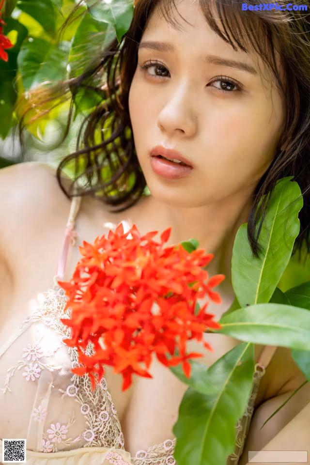 A woman holding a bunch of red flowers in her hand.