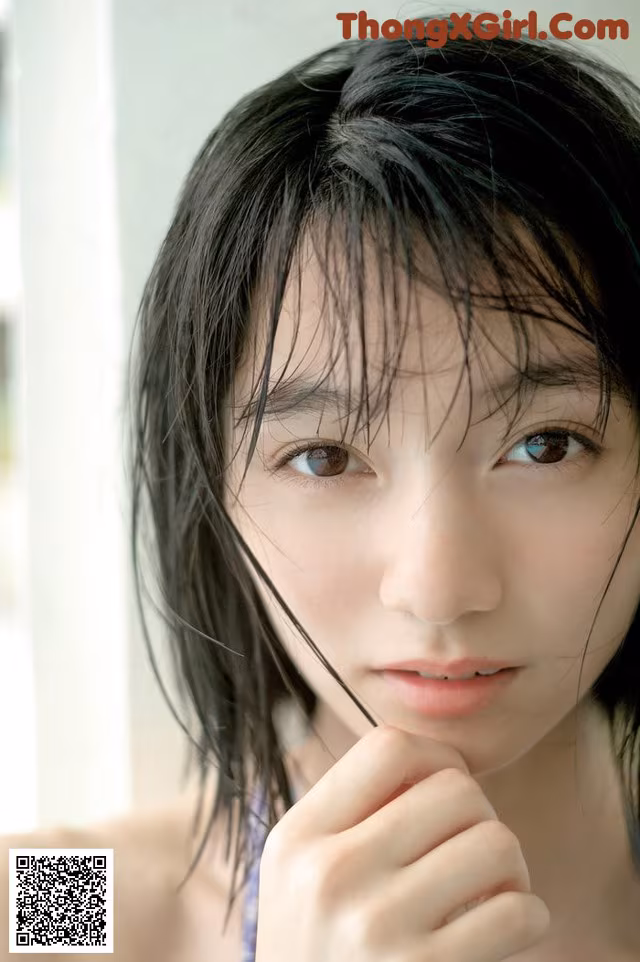 A woman with long black hair is posing for a picture.