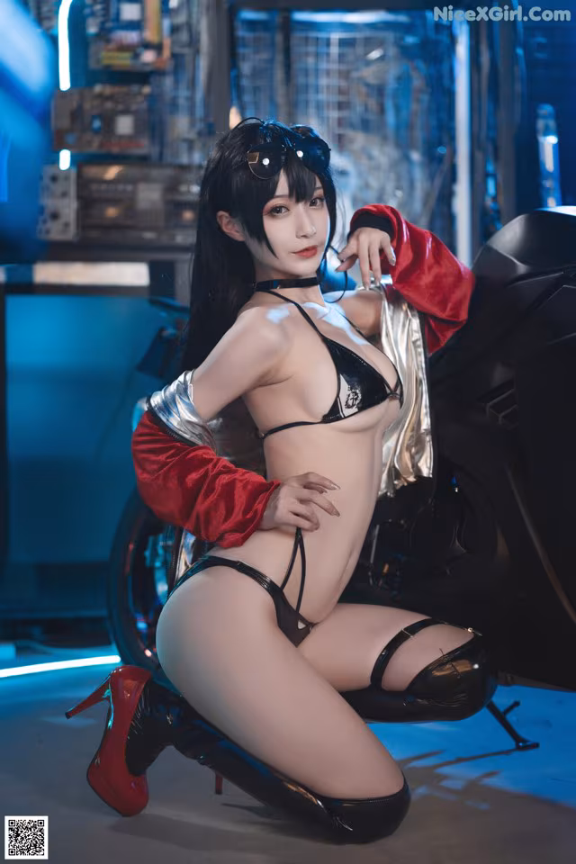 A woman in a black and red outfit posing next to a motorcycle.
